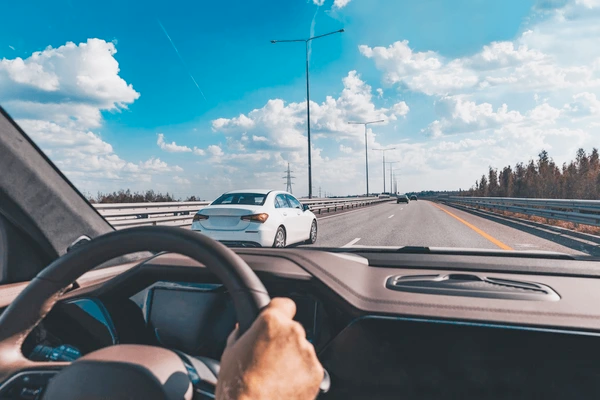 Modern sedan driving on a highway, symbolizing secure auto insurance coverage